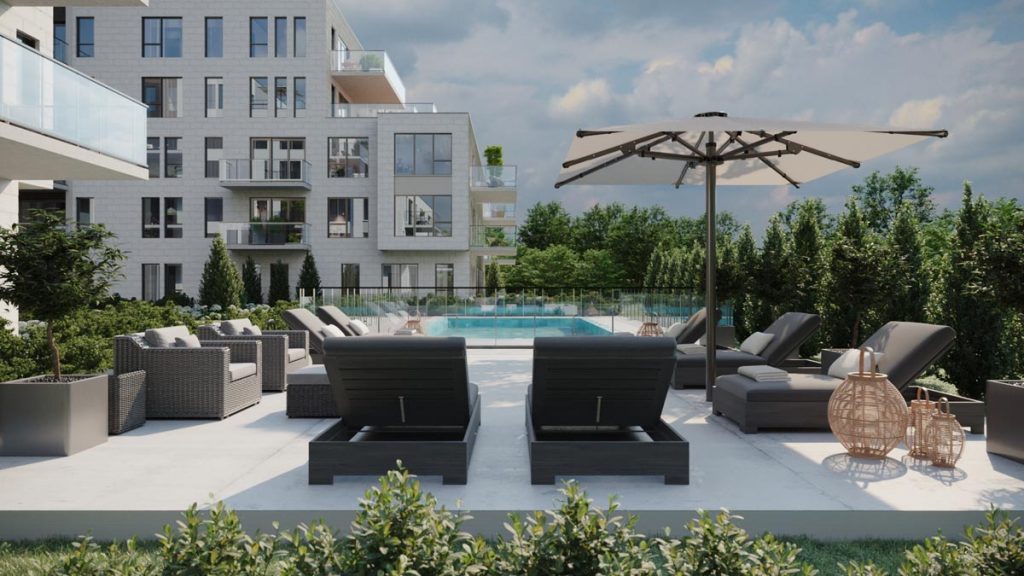 Vue sur la piscine, les chaises et le parasol accessibles depuis le projet de condos à louer Signature Bois-Franc, à Saint-Laurent, Montréal